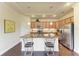 Modern kitchen with a central island, stylish pendant lighting, stainless steel appliances, and sleek cabinetry at 157 Wandering Wetlands Cir, Bradenton, FL 34212