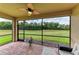 Relaxing screened lanai features brick flooring, ceiling fan, and spacious seating area overlooking a lush yard at 157 Wandering Wetlands Cir, Bradenton, FL 34212