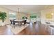 Open-concept living room and dining area with hardwood floors and ample natural light and barstool seating at 157 Wandering Wetlands Cir, Bradenton, FL 34212