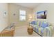 Cozy sitting room with blue and yellow striped couch, beach themed artwork and natural light at 157 Wandering Wetlands Cir, Bradenton, FL 34212