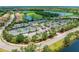 Aerial view of community tennis courts near parking and a lake in a beautiful neighborhood at 157 Wandering Wetlands Cir, Bradenton, FL 34212