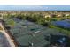 Aerial view of multiple tennis courts with players in a beautiful community near a lake at 157 Wandering Wetlands Cir, Bradenton, FL 34212