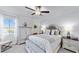 Bright bedroom features neutral decor, a ceiling fan, and a window for natural light at 17576 Holly Well Ave, Wimauma, FL 33598