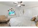 Inviting bedroom featuring white walls, ceiling fan, and beach scene on television at 17576 Holly Well Ave, Wimauma, FL 33598
