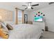 Bright bedroom featuring a ceiling fan and decorative wall art over a dresser and television at 17576 Holly Well Ave, Wimauma, FL 33598