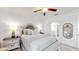 Comfortable bedroom features a neutral color scheme, ceiling fan, and bedside lamps for ambiance at 17576 Holly Well Ave, Wimauma, FL 33598