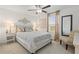 Cozy bedroom featuring a patterned bedspread, side tables with lamps, and neutral decor at 17576 Holly Well Ave, Wimauma, FL 33598