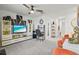 Bonus room with a modern TV, office area, and stylish decor at 17576 Holly Well Ave, Wimauma, FL 33598