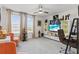Bright bonus room featuring a TV, home office area, and stylish furniture at 17576 Holly Well Ave, Wimauma, FL 33598
