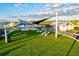 Beautiful community area with green turf, comfortable seating, outdoor TV and well-maintained landscape at 17576 Holly Well Ave, Wimauma, FL 33598