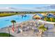 Aerial view of community beach with lounging chairs, poolside bar, and water park elements at 17576 Holly Well Ave, Wimauma, FL 33598