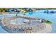 Stunning community pool featuring a splash pad, waterslides, and lounge chairs by the sandy beach at 17576 Holly Well Ave, Wimauma, FL 33598