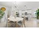 Elegant dining room with a modern chandelier, views into the kitchen, and light-colored walls at 17576 Holly Well Ave, Wimauma, FL 33598