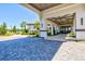 Elegant building entrance with stone pavers, arched walkway, and professionally landscaped surroundings at 17576 Holly Well Ave, Wimauma, FL 33598