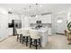 Bright kitchen features a large island with seating, stainless steel appliances, and ample white cabinetry at 17576 Holly Well Ave, Wimauma, FL 33598