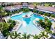 Aerial view of a resort-style pool area with lush landscaping, sun loungers, and inviting blue waters at 17576 Holly Well Ave, Wimauma, FL 33598