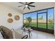 Cozy screened lanai offering a relaxing outdoor space with a ceiling fan and green views at 17576 Holly Well Ave, Wimauma, FL 33598