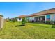 Spacious backyard featuring lush green grass and a screened lanai for outdoor enjoyment at 17578 Holly Well Ave, Wimauma, FL 33598
