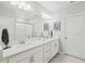 Modern bathroom with double sinks, ample counter space, and a glass-enclosed shower at 17578 Holly Well Ave, Wimauma, FL 33598