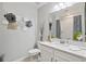 Stylish bathroom showcasing a modern vanity, large mirror, and unique wall decor at 17578 Holly Well Ave, Wimauma, FL 33598