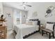 Cozy bedroom with white quilted bedding, decorative wall art, and a ceiling fan at 17578 Holly Well Ave, Wimauma, FL 33598