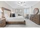 Cozy bedroom with a beautiful bed, dresser, and natural light at 17578 Holly Well Ave, Wimauma, FL 33598