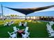 Enjoy the community's outdoor area with a shaded event space and chairs and tables on the lawn at 17578 Holly Well Ave, Wimauma, FL 33598