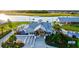 Exterior view of a community recreation center with manicured landscaping, a lake, and a grassy lawn at 17578 Holly Well Ave, Wimauma, FL 33598
