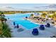 An inviting swimming pool area with ample lounge seating and umbrellas, set amid lush tropical landscaping at 17578 Holly Well Ave, Wimauma, FL 33598