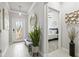 Bright entryway with tile floors, decorative mirror, and plant; a bedroom is just off the foyer at 17578 Holly Well Ave, Wimauma, FL 33598