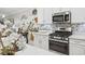 Close up of kitchen featuring stainless steel appliances, white cabinets, and decorative tile backsplash at 17578 Holly Well Ave, Wimauma, FL 33598