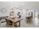 Open-concept kitchen with white cabinets, stainless steel appliances, an island with bar seating, and a wooden dining table at 17578 Holly Well Ave, Wimauma, FL 33598