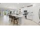 Modern kitchen with white cabinets, stainless steel appliances, a center island with bar stools and open to the living area at 17578 Holly Well Ave, Wimauma, FL 33598