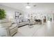 Bright, open-concept living room featuring stylish furniture and decor with tile flooring at 17578 Holly Well Ave, Wimauma, FL 33598