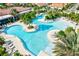 Aerial view of a tropical pool oasis surrounded by palm trees, lounge chairs, and crystal clear water at 17578 Holly Well Ave, Wimauma, FL 33598