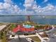 Community area featuring a lighthouse, pool, and clubhouse, surrounded by a scenic lake at 17732 Wayside Bnd, Punta Gorda, FL 33982