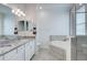 Bathroom featuring double vanity sinks, granite countertops, a soaking tub and glass shower at 17732 Wayside Bnd, Punta Gorda, FL 33982