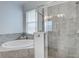 Bathroom showcasing a soaking tub, glass shower, and neutral tile work at 17732 Wayside Bnd, Punta Gorda, FL 33982