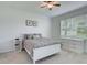 Cozy bedroom with a comfortable bed, neutral decor, ceiling fan, and natural light at 17732 Wayside Bnd, Punta Gorda, FL 33982