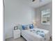 Bright bedroom with a floral bedspread, side table, and neutral carpet at 17732 Wayside Bnd, Punta Gorda, FL 33982