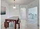 Bright dining area featuring a wooden dining table with bench seating, and a view into a bedroom at 17732 Wayside Bnd, Punta Gorda, FL 33982