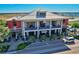 Two-story commercial building with red and white facade featuring a restaurant and retail space with outdoor seating at 17732 Wayside Bnd, Punta Gorda, FL 33982