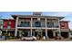 Two-story commercial building with red and white facade featuring a restaurant and retail space with outdoor seating at 17732 Wayside Bnd, Punta Gorda, FL 33982