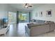 Bright living room with tile flooring, ceiling fan, sliding doors to patio, and comfortable seating at 17732 Wayside Bnd, Punta Gorda, FL 33982