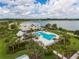 Aerial view of a heart-shaped pool, clubhouse, and lake, surrounded by lush landscaping at 17732 Wayside Bnd, Punta Gorda, FL 33982