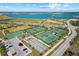 Aerial view of community amenities including tennis and bocce ball courts, set near a picturesque lake at 17732 Wayside Bnd, Punta Gorda, FL 33982