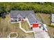 Aerial view of a single Gathering home in a suburban neighborhood with mature trees and sunny skies at 1821 16Th E Ave, Bradenton, FL 34208