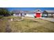 Charming single-story home featuring a red garage door and accent trim, set against a clear blue sky at 1821 16Th E Ave, Bradenton, FL 34208