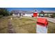 Charming single-story home featuring a red garage door and accent trim, set against a clear blue sky at 1821 16Th E Ave, Bradenton, FL 34208