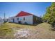 The back of the house with partial paint in red and white, with a yard in need of landscaping at 1821 16Th E Ave, Bradenton, FL 34208